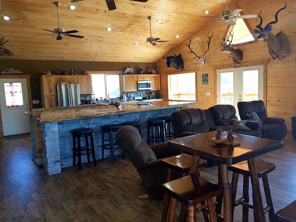A cabin interior with a stone island bar, wooden furniture, and antler decorations. - Beautiful 4-bedroom cabin with WiFi, AC in superb Fairfield (Fairfield)