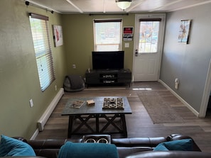 Una sala de estar con televisor, mesa de centro y sofá.
