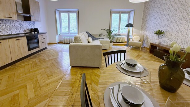 En modern lägenhet med kök, matplats och vardagsrum.