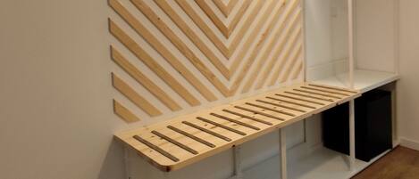 Een moderne, minimalistisch ingerichte kamer met een bank en een wandplank.