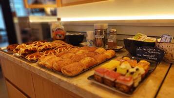 Une vitrine de boulangerie présentant diverses pâtisseries, avec une pancarte indiquant qu’il y a un assortiment de pâtisseries portugaises et espagnoles.