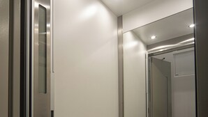 A modern elevator with a metallic finish and a glass door. - Bacalhoeiros 125 Hotel (Lisbon)
