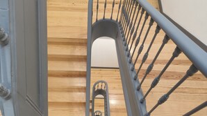 A spiral staircase with a central elevator shaft. - Bacalhoeiros 125 Hotel (Lisbon)