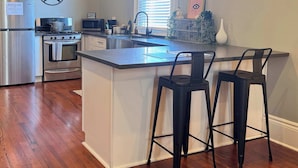 A modern kitchen with a central island, stainless steel appliances, and a star decoration on the wall.