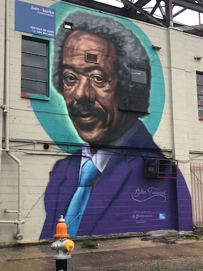 Um mural retrata um homem de terno numa parede de edifício.