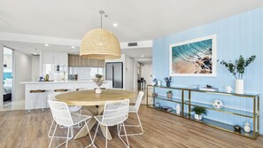 Enjoy meals in the spacious kitchen with a central island and dining area featuring a round table and pendant light.