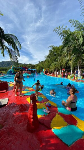 A swimming pool with colorful tiles and palm trees in the background.
