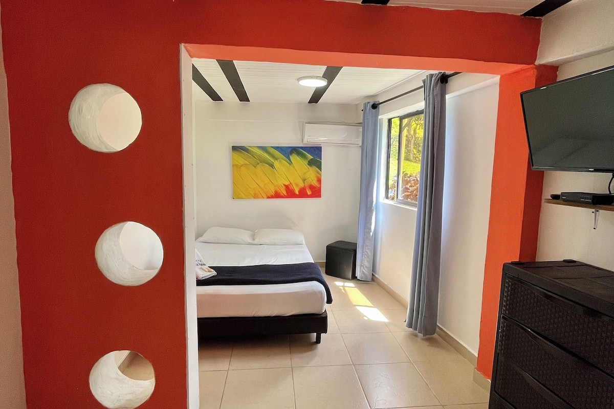 Una habitació d'hotel amb un llit, una televisió, una petita taula de nit i un quadre a la paret.