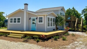 Une maison à deux étages avec un porche à l’avant, une cheminée et une terrasse.