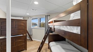 A bunk bed room with a window, wooden flooring, and a white ceiling. - Pleasant Cove Waterfront Getaway With Fire Pit, Deck, and Lake Views (Mooresville)