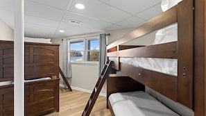A bunk bed room with a window, wooden flooring, and a white ceiling. - Pleasant Cove Waterfront Getaway With Fire Pit, Deck, and Lake Views (Mooresville)