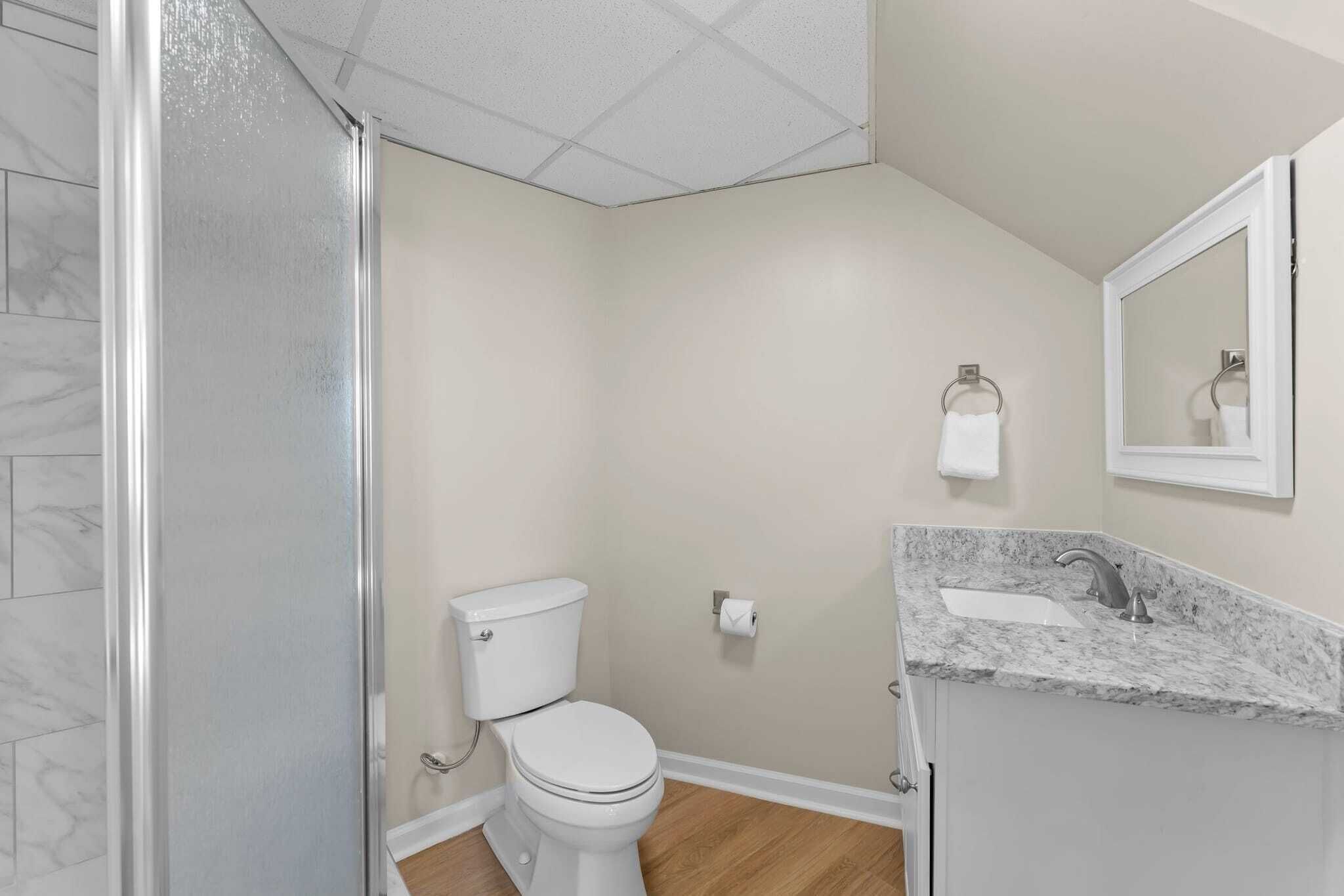 A bathroom with a toilet, sink, and shower.