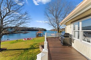 A deck with a grill, overlooking a lake with a dock and a gazebo. - Pleasant Cove Waterfront Getaway With Fire Pit, Deck, and Lake Views (Mooresville)