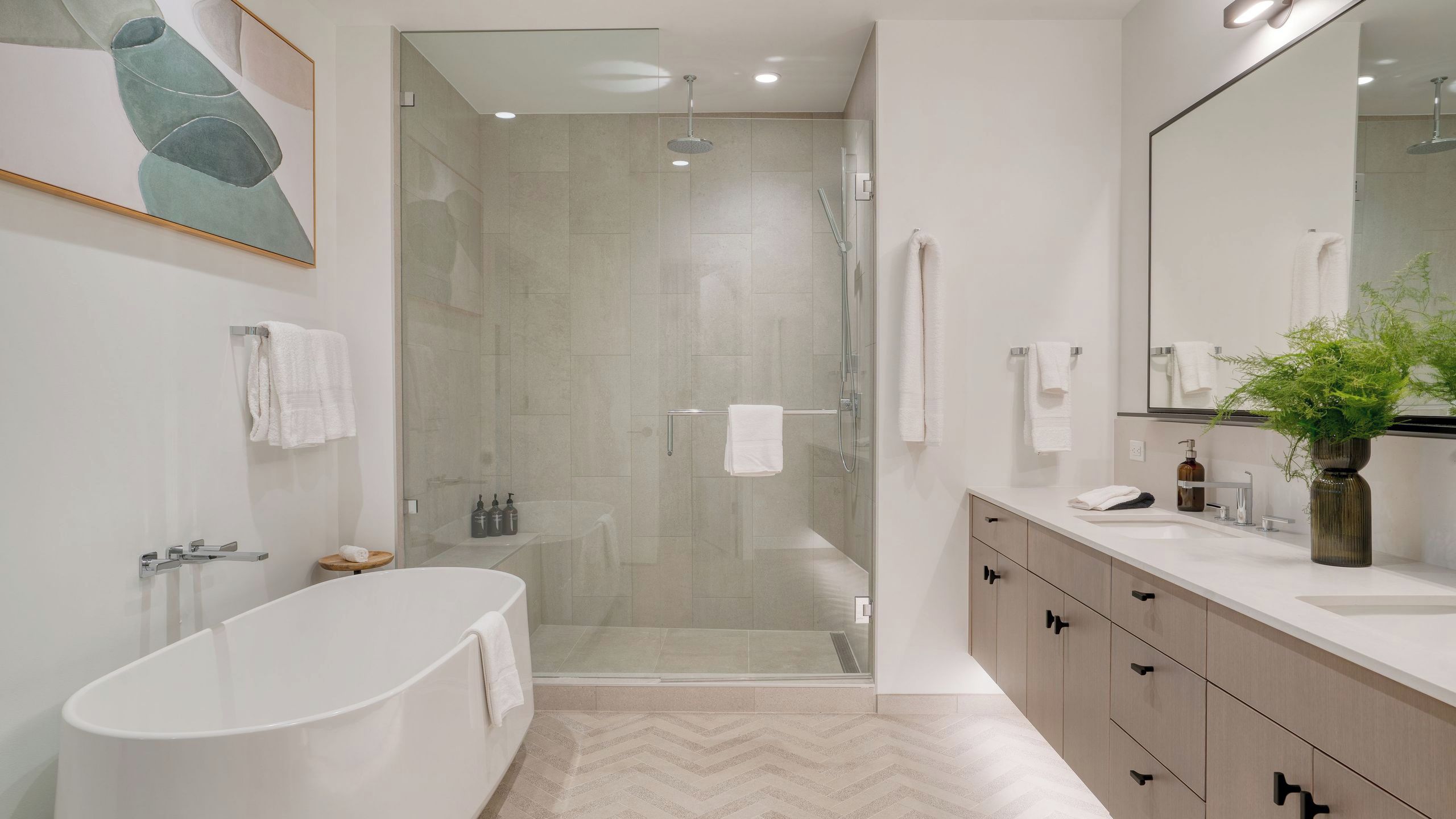 A modern bathroom with a freestanding bathtub, a glass-enclosed shower, and a vanity with a mirror and sink.