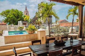 A rooftop terrace with a pool, dining area, and views of historic buildings. - Estrella de San Pedro by Zakher (Cartagena)