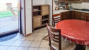 Una cocina con mesa, sillas y vistas al exterior.