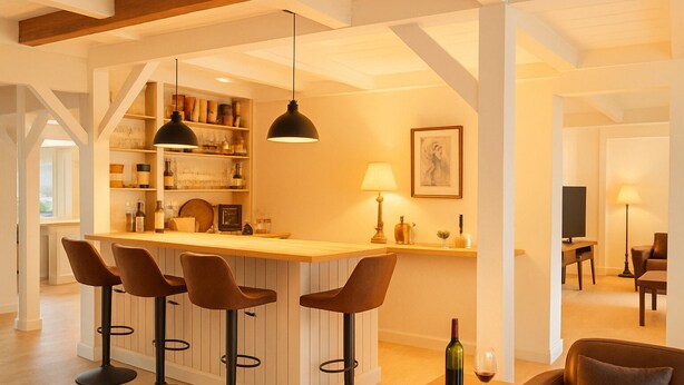 Una cocina moderna con barra, vigas de madera y un comedor con sofá y mesa.