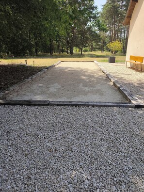 A gravel pathway leading to a building with a bench and a planter. - Estate in Sologne with a pool!! (Selles-Saint-Denis)