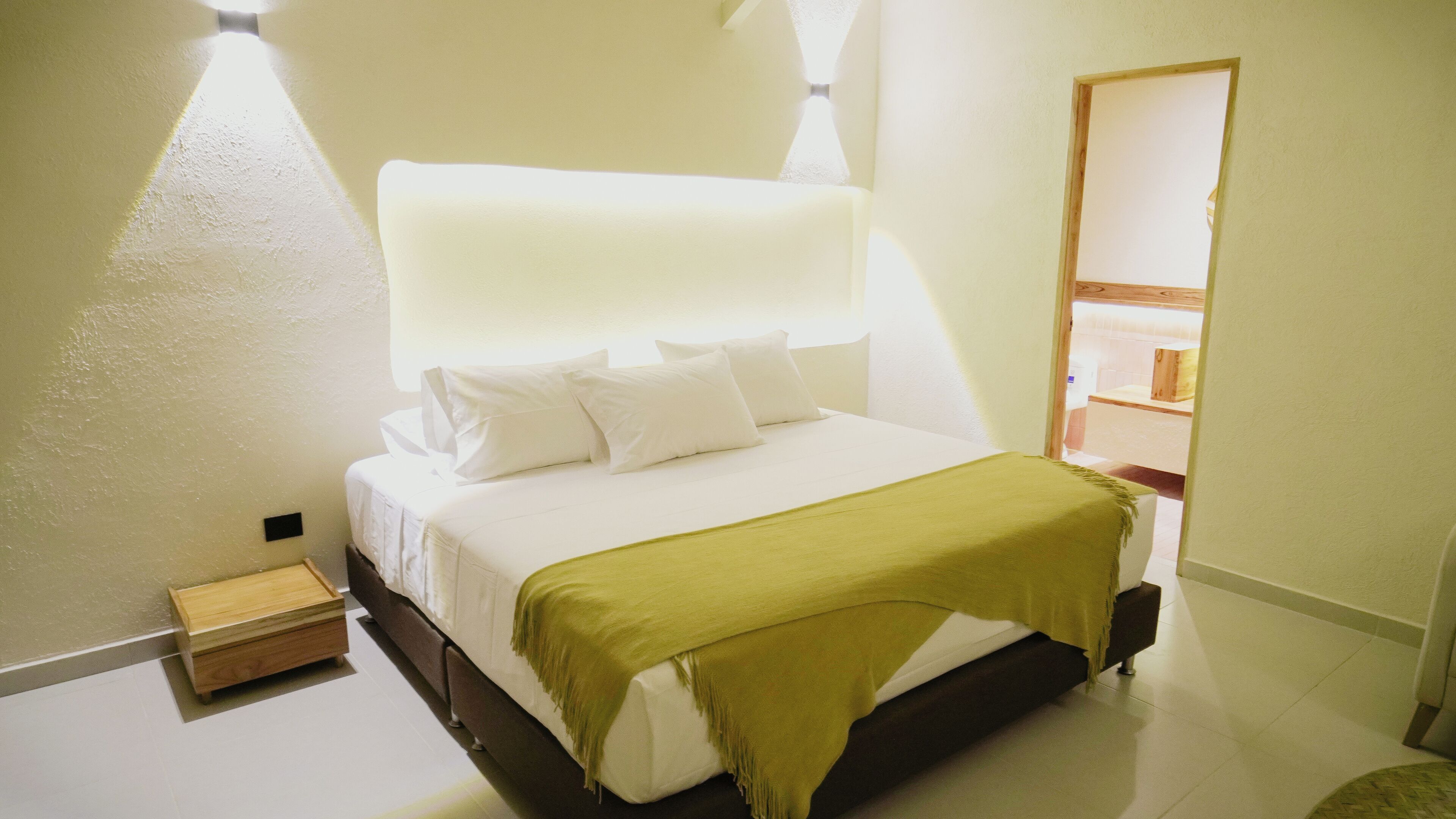A bedroom with a bed, pillows, a bedside table, and a nightstand.