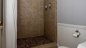 A bathroom with a shower, toilet, and a towel rack. - Luxury Hot tub Suite w/ In-Room Hot Tub & King Bed 1BR, 1BA (Nashville)