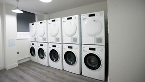 A laundry room with multiple stacked washing machines and dryers.