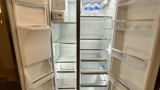 An open refrigerator with multiple shelves and a water dispenser. - 3 Bed 1.5 Bath Pet Friendly Apt (Columbia)