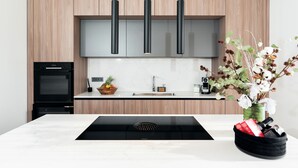 A modern kitchen with wooden cabinets, a black range hood, a built-in oven, and a stainless steel sink. - Villa SUN Villa with pool and sea view (Labinci)