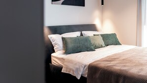A modern bedroom with a bed, pillows, and a hanging light fixture. - Villa SUN Villa with pool and sea view (Labinci)