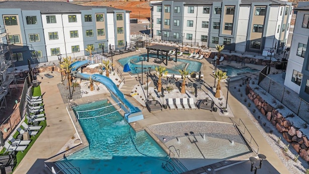 Un hotel con múltiples piscinas, zonas de estar al aire libre y montañas al fondo.