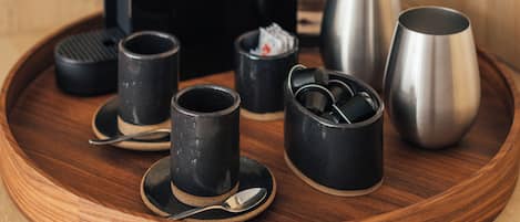 Ett träbricka med en kaffebryggare, koppar och en termos.
