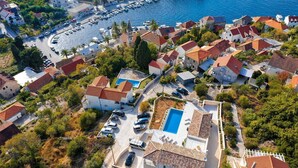 An aerial view of a coastal residential area with houses, a marina, and a large swimming pool. - Villa Sea Whisper - location and charm by MyWaycation (Splitska)