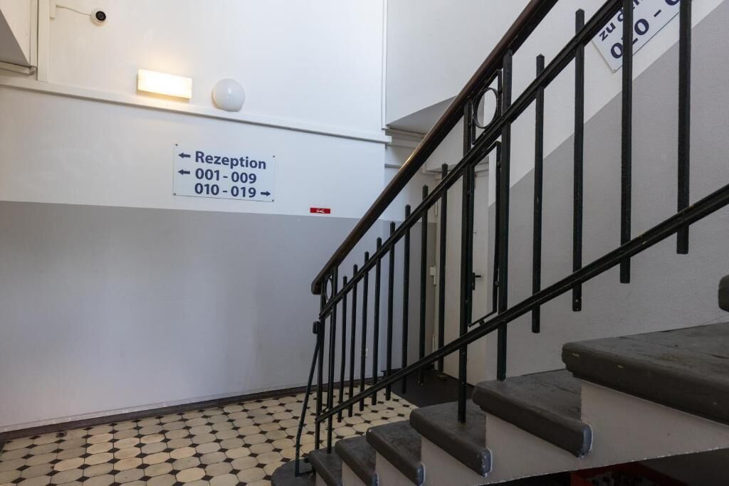 A staircase with a reception sign indicating phone numbers 001-009 and 010-019.