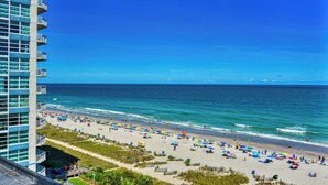 A beach with a high-rise hotel in the background. - Ocean Front, Private Balconies (Myrtle Beach)