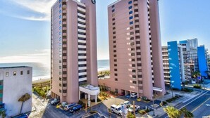 A high-rise hotel with a beach view, multiple balconies, and a parking area. - Ocean Front, Private Balconies (Myrtle Beach)