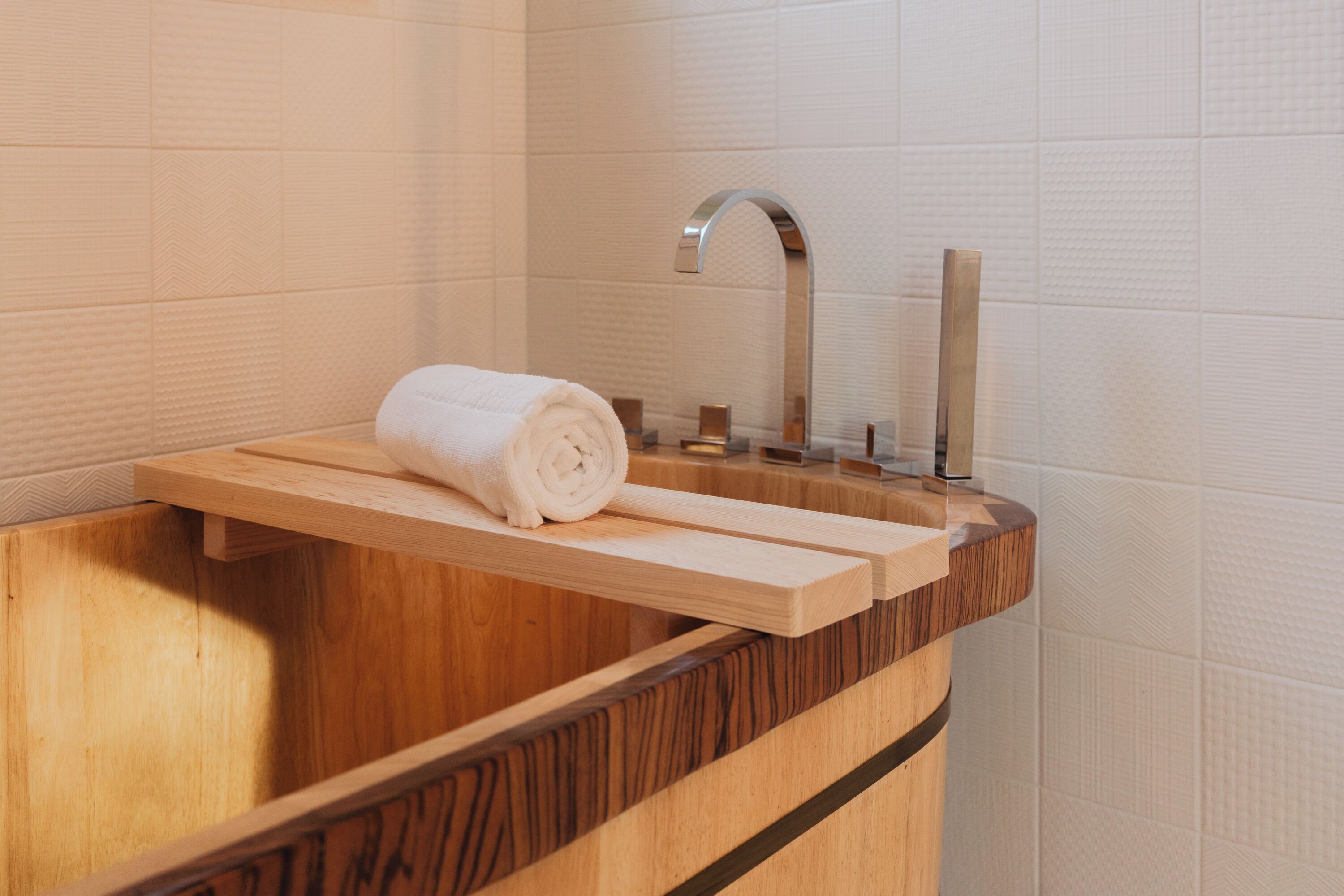 A wooden vanity with a built-in sink and a towel holder.