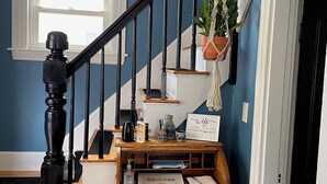 Una escalera con un escritorio de madera y una planta colgante.