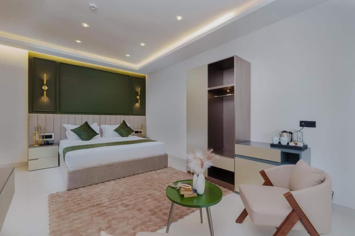 A modern bedroom with a bed, bedside tables, a wardrobe, and a seating area.