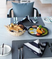 Una mesa de comedor con una cesta de pan, un plato de huevos, verduras y una ensalada pequeña.