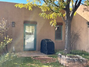 Un edificio con fachada marrón, una puerta verde y un objeto cubierto en el suelo.