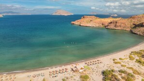 A beach with clear turquoise water, a sandy shore, and rocky outcrops in the distance. - Stay at the Beautiful Villa De Palmar Islands of Loreto.   (loreto)