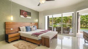 Un dormitorio moderno con una cama de madera, un ventilador de techo y vistas a una piscina y follaje.