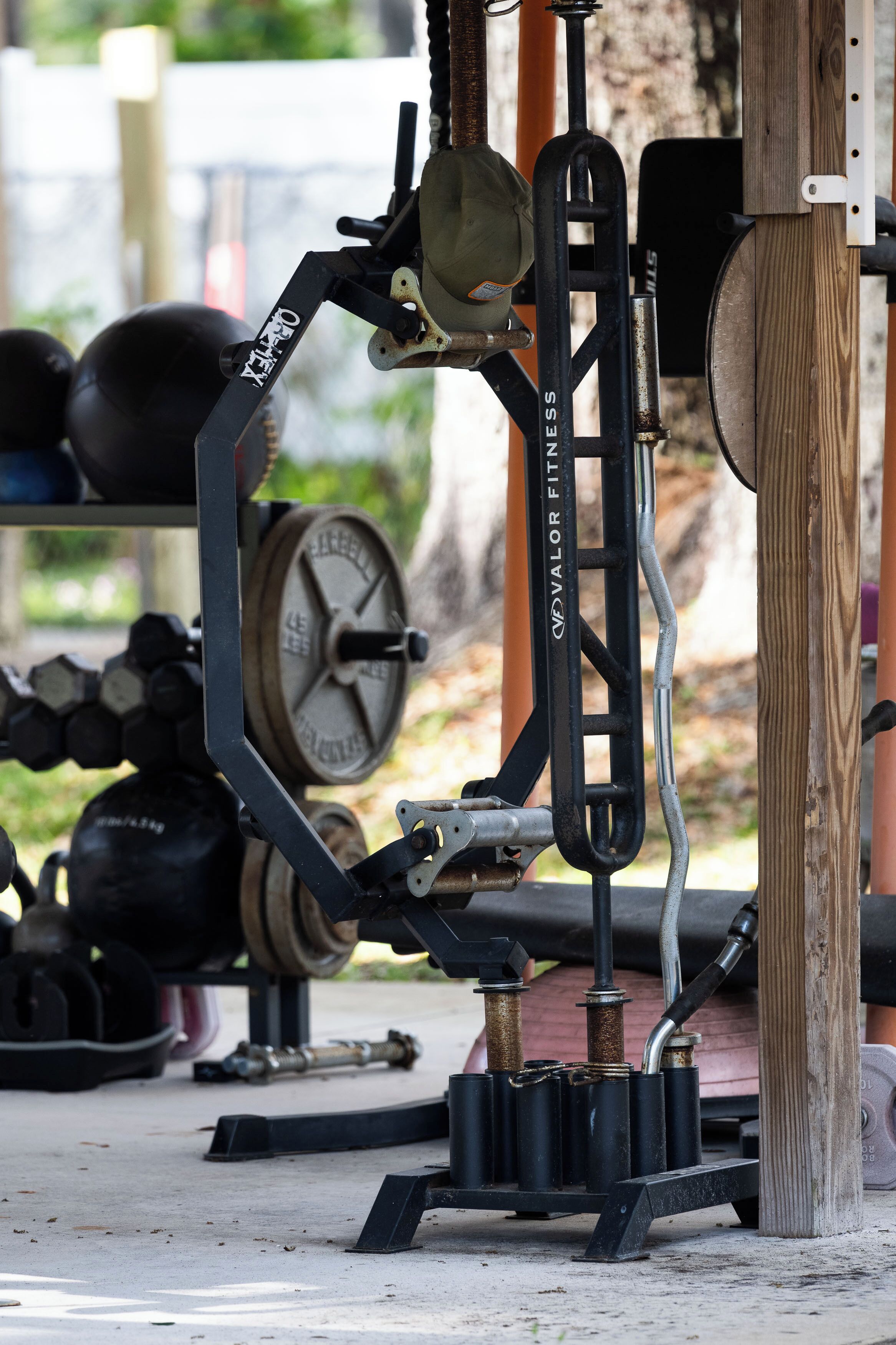 A weightlifting station with a bench press, adjustable dumbbells, and a weight stack.