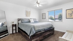 A bedroom with a bed, a ceiling fan, a window, and a framed picture on the wall. - Charming 4-bedroom house with AC and WiFi in welcoming Twin Falls (Twin Falls)