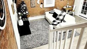 Een gezellige woonkamer met een witte bank, een kerstboom en een metselwerk muur.