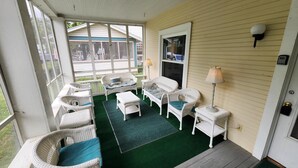 A covered porch with wicker furniture, a green carpet, and a view of a house in the background. - 162 Peach Perfectly Located inside Lakeside! (Lakeside)