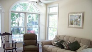 A living room with a rocking chair, a sofa, and a large window with a view of the outside. - 343 Oak Ave in Lakeside (Lakeside)