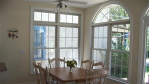 A dining area with a wooden table and six chairs, large windows, and a ceiling fan. - 343 Oak Ave in Lakeside (Lakeside)