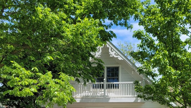 A two-story house with a front porch, a balcony, and a gravel driveway. - 533 Sycamore in Lakeside (Lakeside)