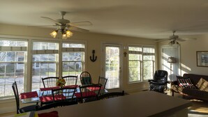 A dining area with a table and chairs, a ceiling fan, and large windows with blinds. - 533 Sycamore in Lakeside (Lakeside)