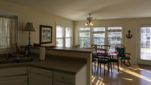A kitchen with a dining area, large windows, and a ceiling fan. - 533 Sycamore in Lakeside (Lakeside)